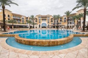 a large pool in front of a building with palm trees at Beautiful 3 bed villa on Mar Menor golf resort in Torre-Pacheco