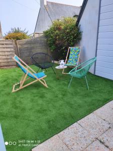 two chairs and a table in a yard at gite steir in Penmarch +5 photos