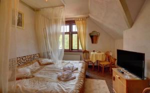 sypialnia z łóżkiem, telewizorem i stołem w obiekcie Rezydencja Biały Jar w mieście Karpacz