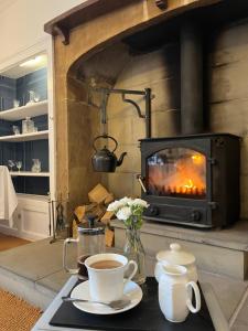 a table with a cup of coffee and a fireplace at Burnley country house in Hutton le Hole