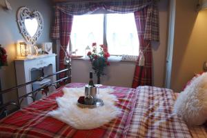 Una cama con una manta y una botella de vino. en West Horizon holiday cottage, en Lochinver