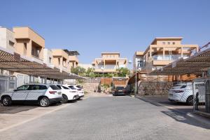 a parking lot with cars parked in front of buildings at La suite eilat in Eilat