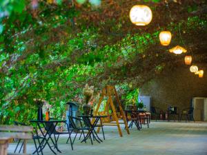 un groupe de tables et de chaises sous un arbre dans l'établissement Dunhuang Hu Yang Inn, à Dunhuang