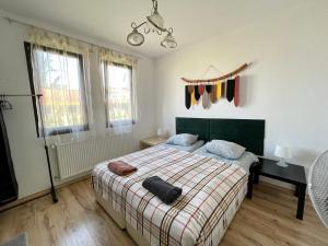 a bedroom with a bed with a checked blanket and windows at Kassandrova Guest House & Spa in Bratsigovo +65 photos