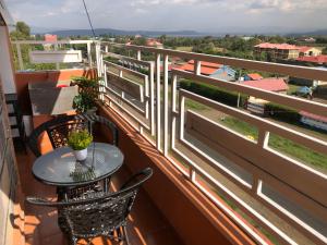 a balcony with a table and chairs and a view at Comfort Stay in Nakuru