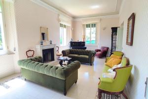 ein großes Wohnzimmer mit Sofas und einem Kamin in der Unterkunft Villa Fazi - Liberty Style Villa With Private Pool & Park in Ortezzano