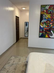 a room with a bed and a painting on the wall at Guided Hospitality - Luxury Accommodations in Lagos