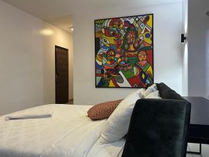 1 dormitorio con 1 cama con una pintura en la pared en Guided Hospitality - Luxury Accommodations, en Lagos