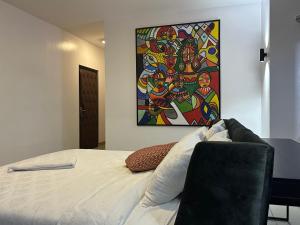 a bedroom with a bed with a painting on the wall at Guided Hospitality - Luxury Accommodations in Lagos