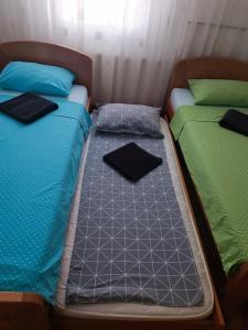 2 Betten nebeneinander in einem Zimmer in der Unterkunft Serbian home with garden in Krnjača