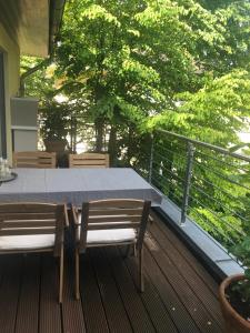 a table and chairs on a deck with trees at Alterwanderweg Haus in Hamburg