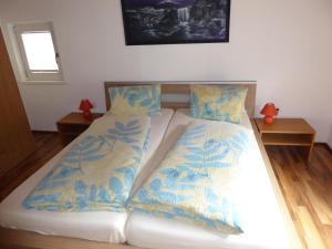 a bedroom with a bed with blue and white sheets at Haus Can in Dalaas