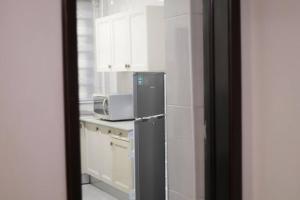 uma cozinha com um frigorífico e um micro-ondas em Jeffston Court Apartments em Acra