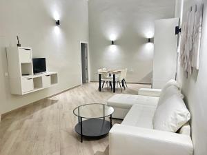 uma sala de estar com um sofá branco e uma mesa em Ribera Home em Córdoba