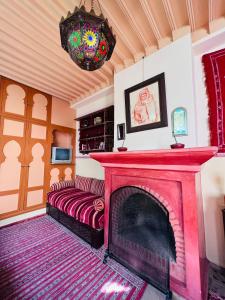a living room with a fireplace with a red mantle at Riad Al Nour in Marrakech +37 photos