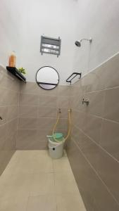 łazienka z toaletą i lustrem na ścianie w obiekcie Tok Abah Homestay Bukit Mertajam w mieście Bukit Mertajam
