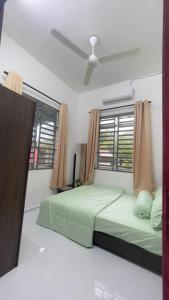 um quarto com uma cama verde e uma janela em Tok Abah Homestay Bukit Mertajam em Bukit Mertajam