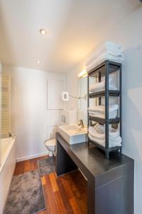 een badkamer met een wastafel en een aanrecht met een stapel handdoeken bij Sensational Studio in Brussels City Fantastic Location in Brussel