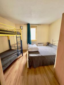 a bedroom with two bunk beds and a wooden floor at La Mongie - Apt 2 ch - 8 pers - Place parking couvert in La Mongie