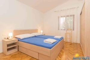 a bedroom with a bed with blue sheets and a window at Apartment in Njivice/Insel Krk 27855 in Njivice