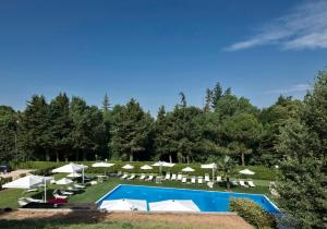 un complejo con piscina, tumbonas y sombrillas en Il Castagneto Hotel, en Melfi