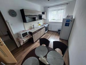 una pequeña cocina con mesa y nevera en Vaclavskeho Apartment Medzilaborce, en Medzilaborce