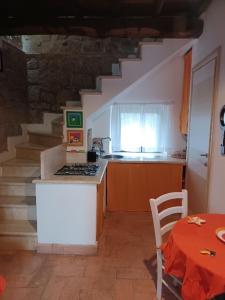 una cucina con scala con tavolo e tavolo e tavolo di Alloggio turistico Il Villino in Maremma a Farnese