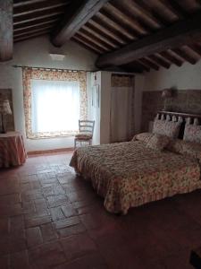 una camera con un letto e una grande finestra di Alloggio turistico Il Villino in Maremma a Farnese