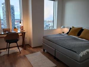 une chambre avec un lit, un bureau et une fenêtre dans l'établissement Huoneisto Nokia Areenan yhteydessä, à Tampere