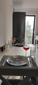 een tafel met twee glazen wijn op een aanrecht bij Infinit relax in Târgu Jiu