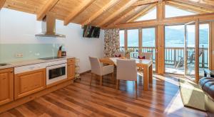 cocina y comedor con mesa y sillas en Chalet´s am See, en St. Wolfgang