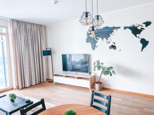 una sala de estar con TV y un mapa mundial en la pared en UP 34 FLOOR APARTMENTS, en Klaipėda