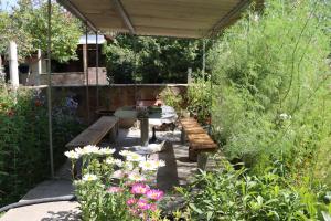 a patio with a table and benches in a garden at SELINA GUEST HOUSE in Byurakan