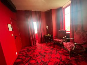 a red room with a chair and a window at La Maison à Pan De Bois Chambre Napoléon III in Vierzon
