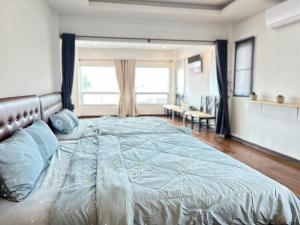 a bedroom with a large bed with blue pillows at Los Inn Nakhon ลอส อินน์ นคร in Nakhon Phanom