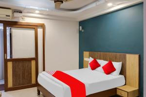 Un dormitorio con una cama con almohadas rojas. en Hotel O Sea View Inn, en Chennai