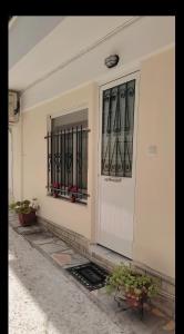 a white door of a building with a window at ANASTASIA studio in Kavala