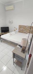 a bedroom with a bed and a table with a lamp at ANASTASIA studio in Kavala