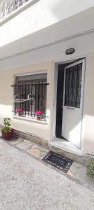 a white house with a black door and windows at ANASTASIA studio in Kavala