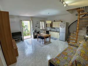 una cucina e un soggiorno con tavolo e frigorifero di Casa Vacanza AcquaMarina ad Acireale