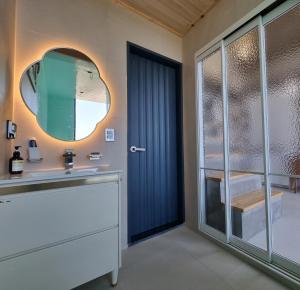 ein Bad mit einem Waschbecken und einem Spiegel in der Unterkunft Dalthor Pension in Jeju-do