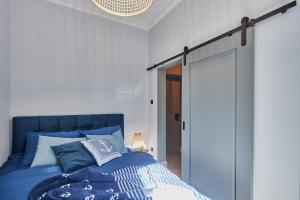 um quarto com uma cama azul e uma porta de vidro deslizante em Apartamenty Świnoujście - Apartament Bella em Świnoujście
