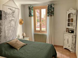 Un dormitorio con una cama verde y una ventana en Douceur d'Azur en Niza