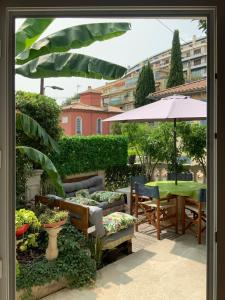 a patio with a table and chairs and an umbrella at Douceur d'Azur in Nice