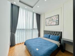 een slaapkamer met een blauw bed en een raam bij Nanahousing-Apartment Vinhomes Skylake #1BR#2BR#3BR in Hanoi