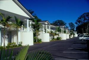 a white house with trees and houses at Runaway Bay Motor Inn in Gold Coast