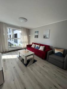 a living room with a red couch and a table at New Apartment - near Sky Tower - 7 People - New Building - Parking Place in Wrocław