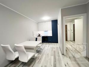 a white kitchen with a table and white chairs at New Apartment - near Sky Tower - 7 People - New Building - Parking Place in Wrocław