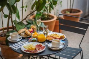 a table with breakfast foods and drinks on it at Hotel Boutique Casas de Santa Cruz in Seville +52 photos