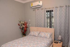 a bedroom with a bed and a vase of flowers at Zegio Villa in Jomo